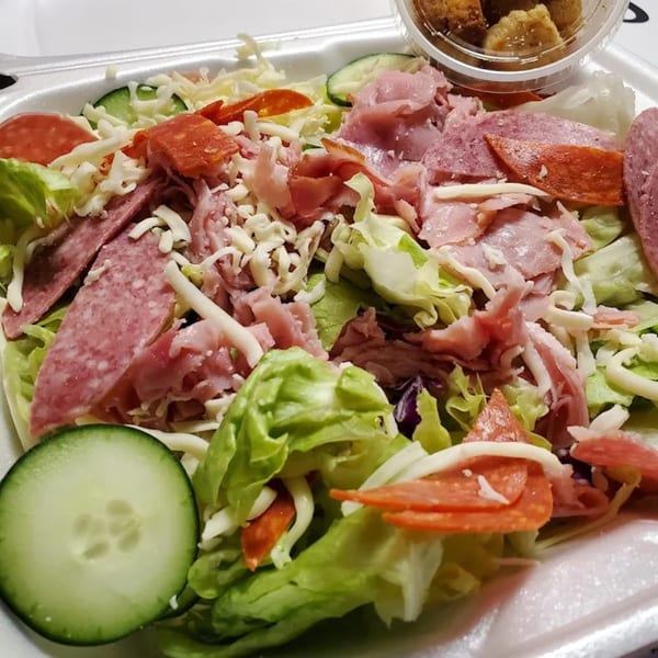 Catanzaro's Pizza & Subs chef salad with lettuce, ham, salami, pepperoni, cheese, and cucumbers.